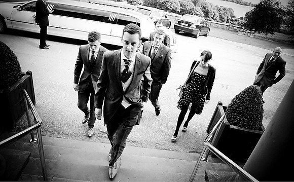 black and white reportage wedding photography of groom and bridal party arriving at wortley hall in sheffield