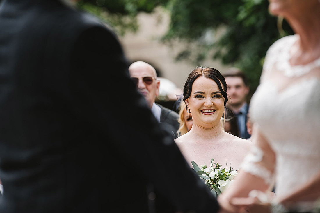 aston hall hotel wedding brides daughter smiles framed by bride and groom