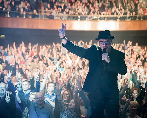 sheffield gig photography of John reilly singing peace sign at sheffield city hall concert
