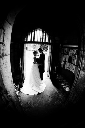 black and white reportage wedding photography of kiss in church door
