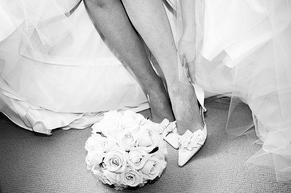 Photography of bride putting on her wedding shoes