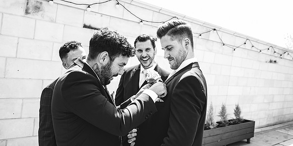 best man getting help with pocket square at aston hall hotel wedding
