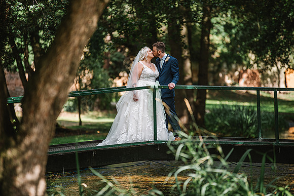 old-vicarage-at-elkesley-nottinghamshire-wedding-photography-bride-and-groom-kissing-on-bridge