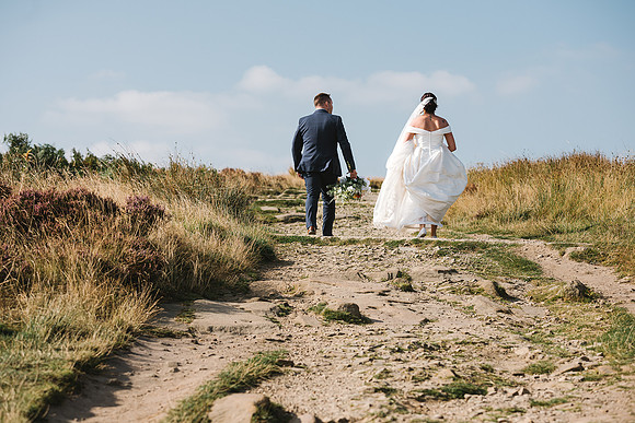 bride-and-groom-walking-at-curbar-edge-in-the-peak-district